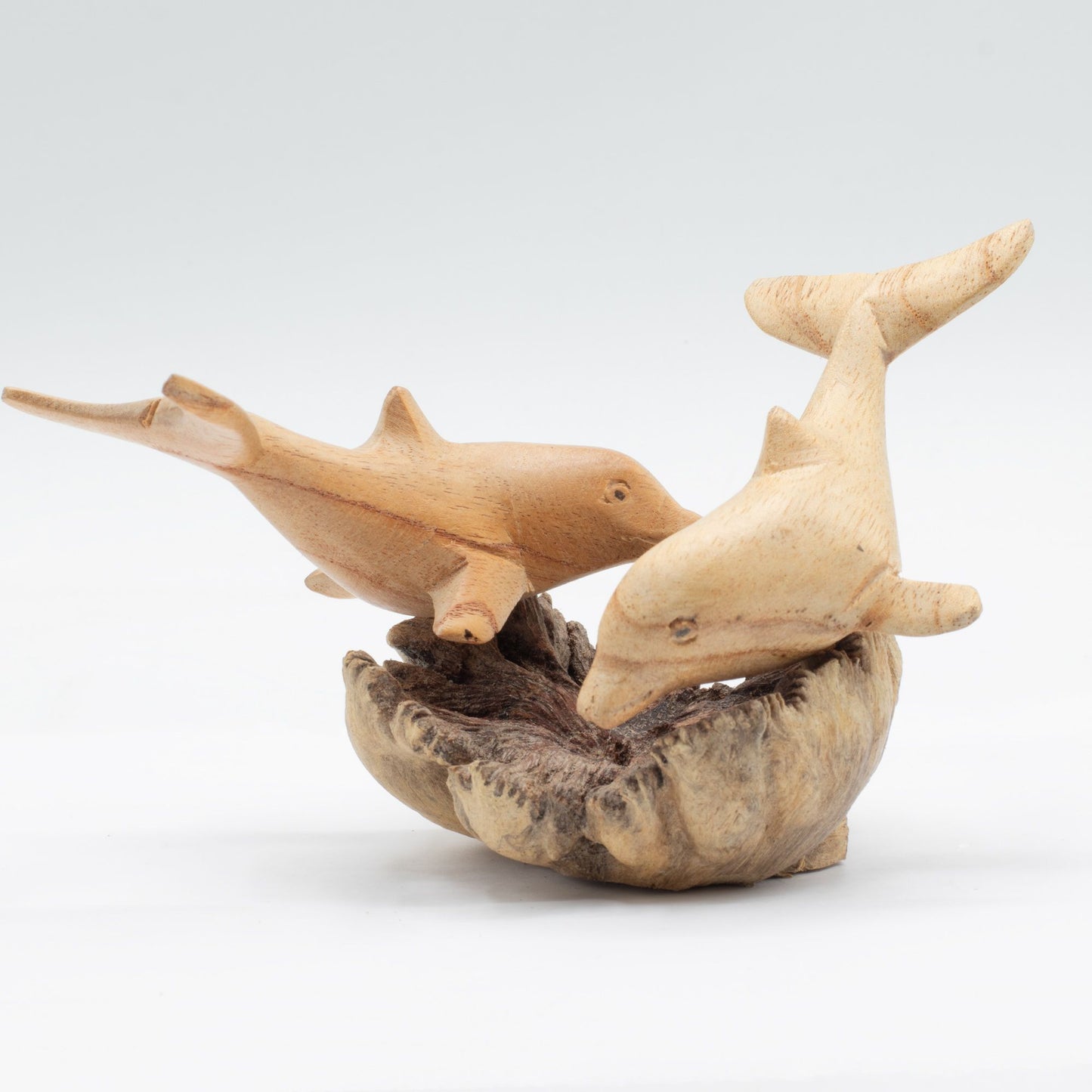 Handmade Parasite Wood Art Carving Dolphins in Play against a white background