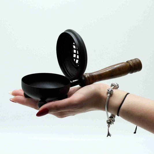 Hand holding a Medium Iron Censer Incense Burner - Gold detail against a white background