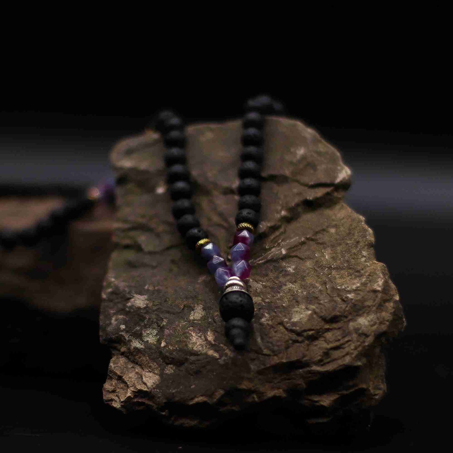 Essence of the Volcano Necklace on a dark rock background