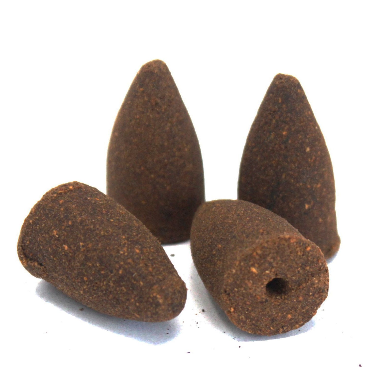 Four brown incense cones on a white background