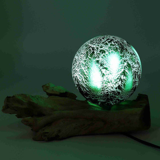Glass orb with a green light on a dark background
