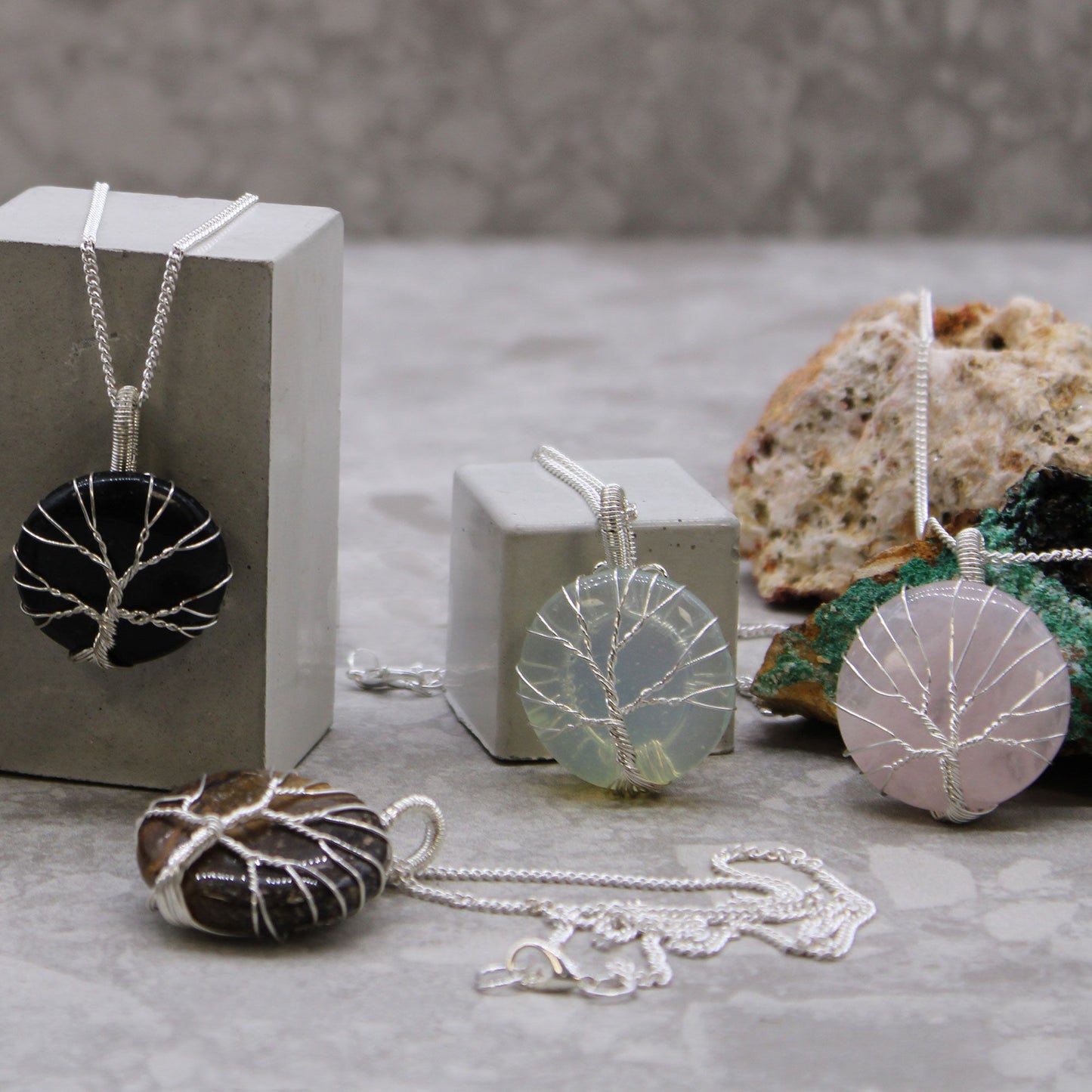 Jewelry with tree-of-life designs on a neutral background