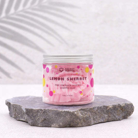 Jar of pink lemon sherbet whipped soap on a stone surface with a white background