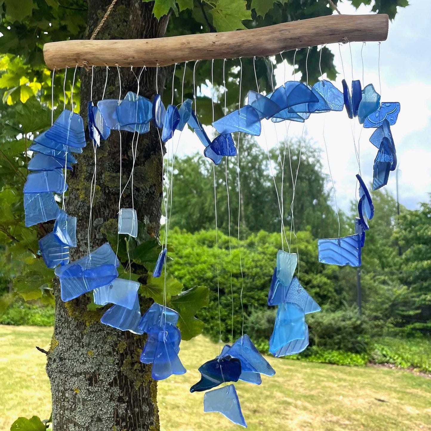 Recycled Glass Wind Chime - Blue hanging from a branch with a natural background