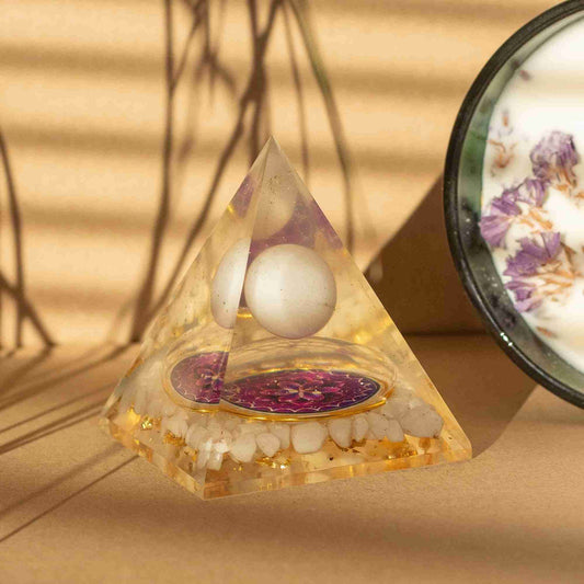 Pyramid-shaped crystal with spherical stones on a beige background