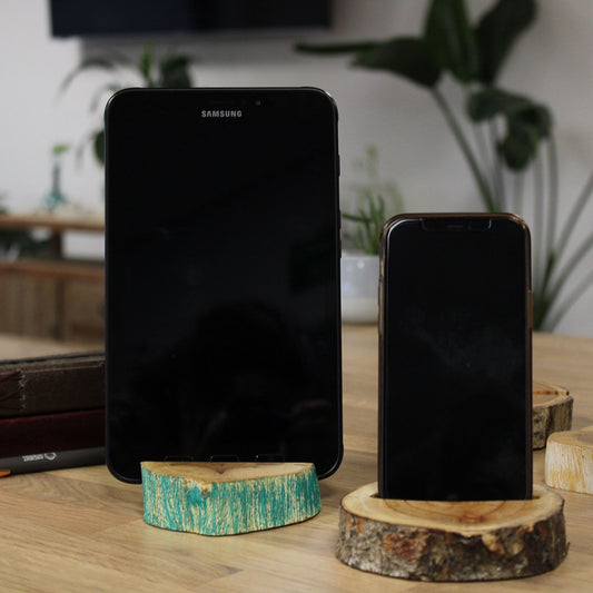 Two smartphones on wooden stands with a blurred indoor background
