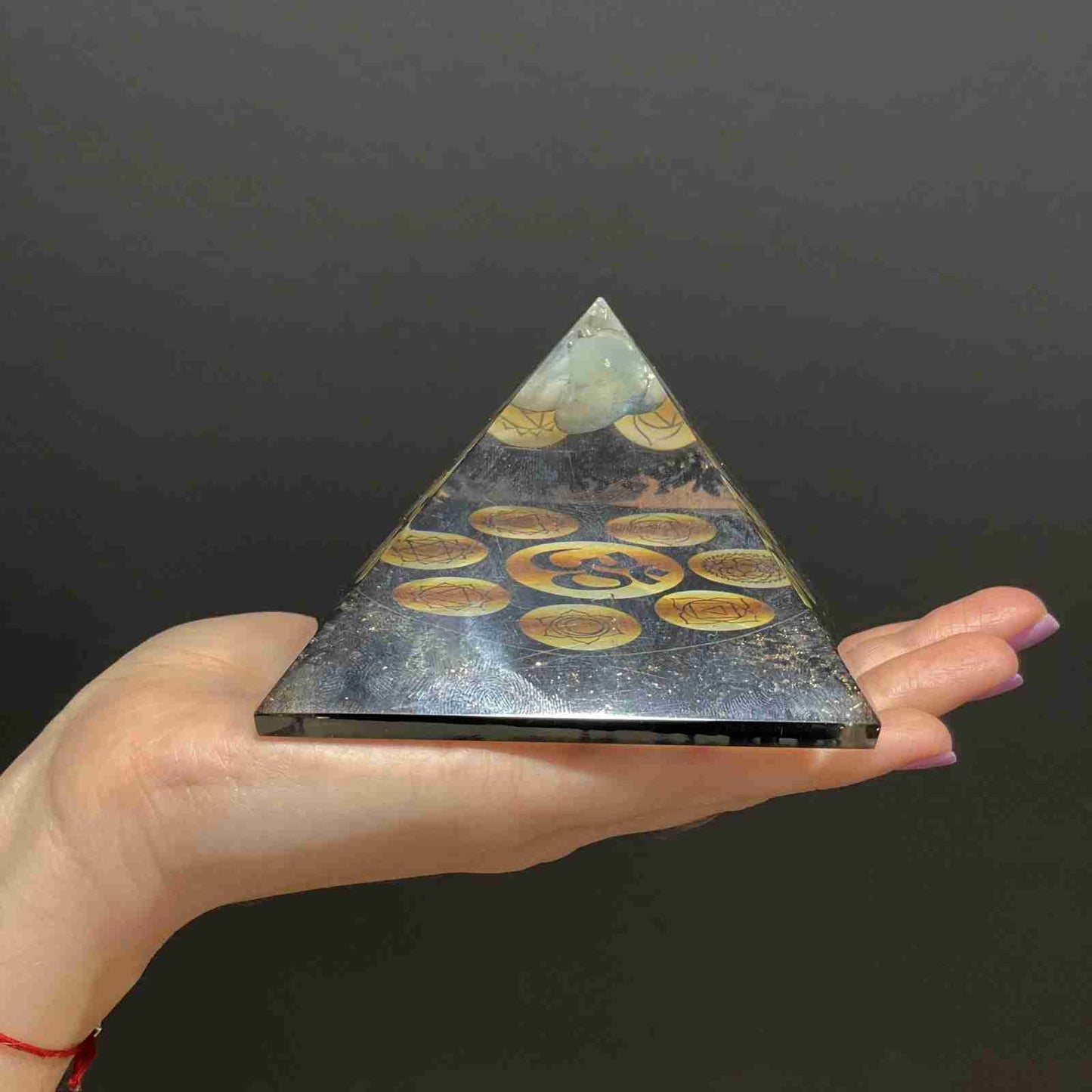 Orgonite Pyramid - Midnight Om Chakra held in a hand