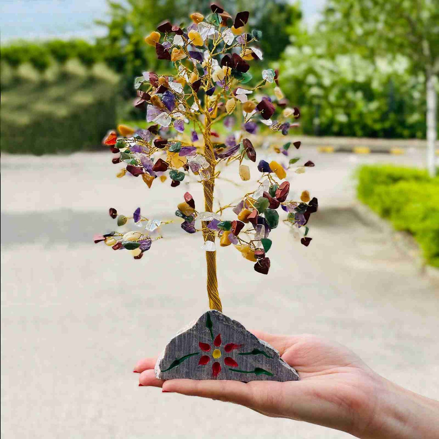 Indian Gemstone Tree - Multi-Gem (320 Stones) held by a hand with a blurred outdoor background