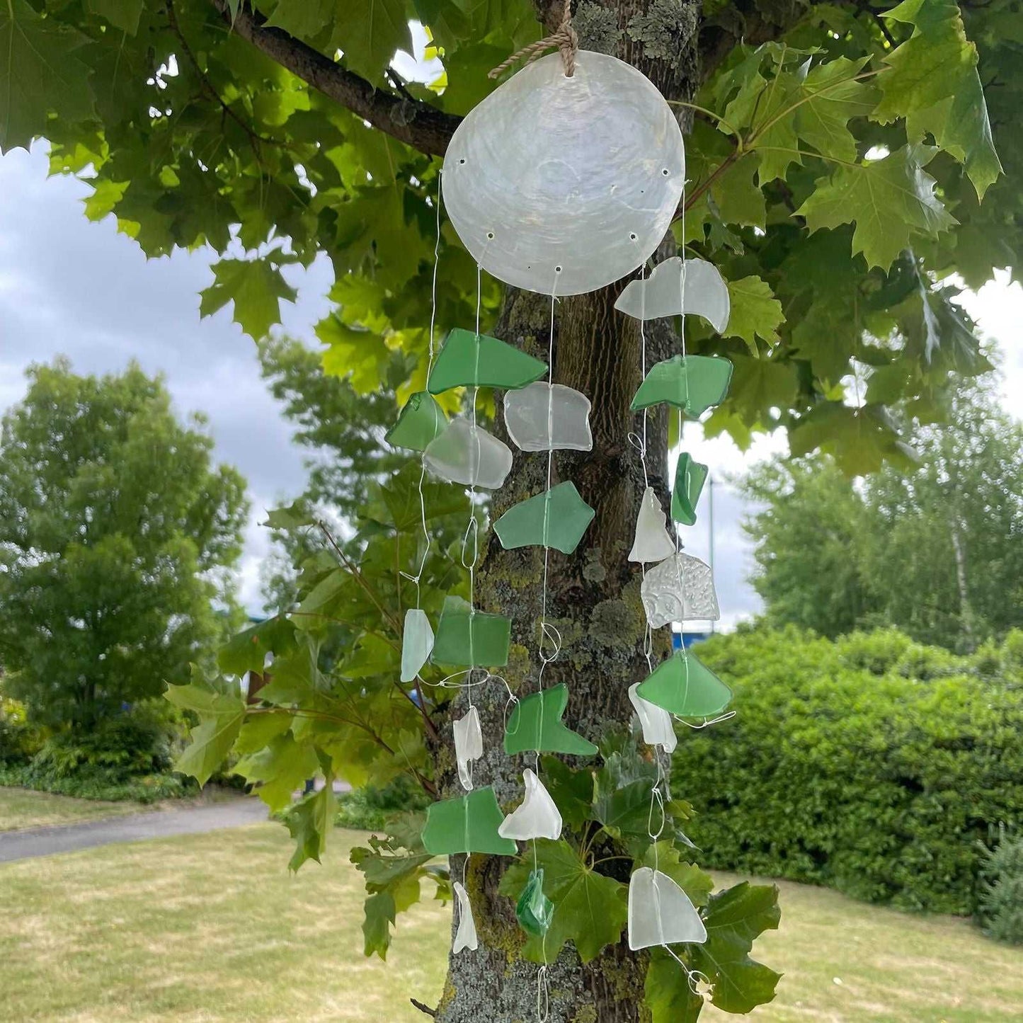 Copis & Glass Drop - Green & White Glass hanging from a tree