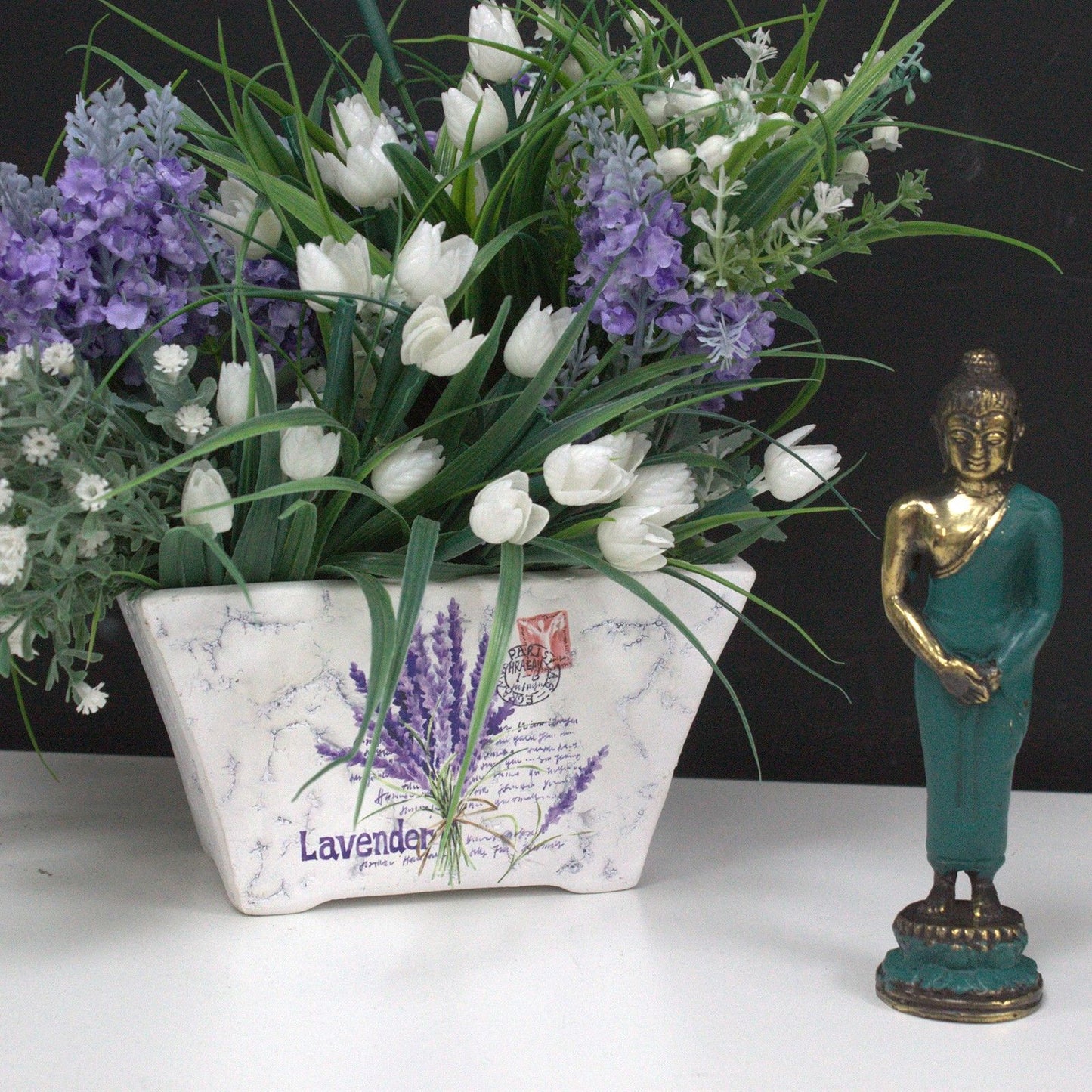 Floral arrangement with lavender and white tulips in a decorative pot, accompanied by a Medium Standing Brass Buddha Figurine