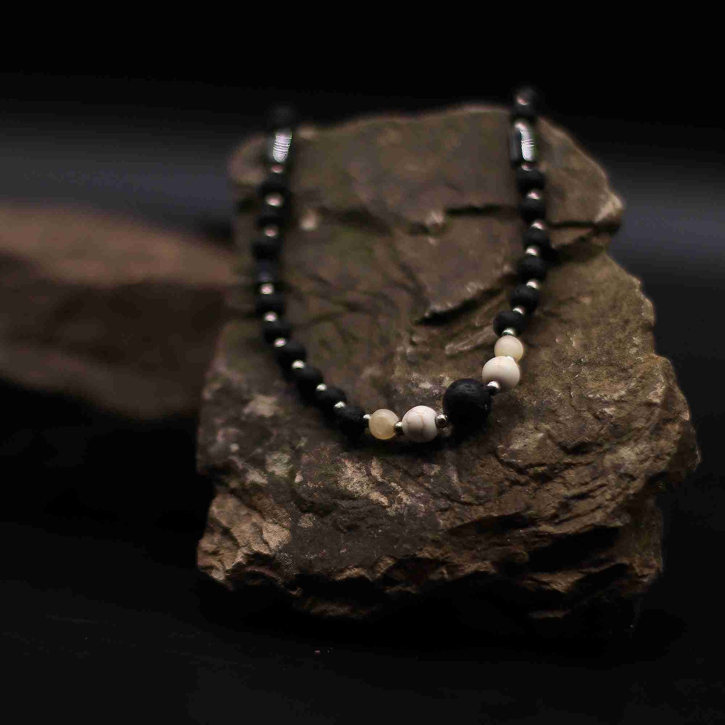 Essence of the Volcano Necklace - Cultural Connection close up view on a rock