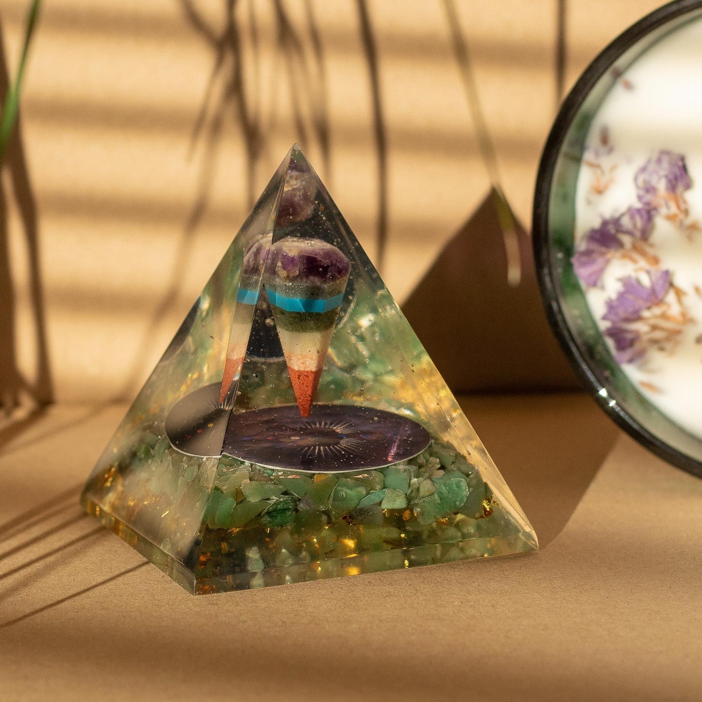 Triangular crystal pyramid with embedded stones on a beige surface