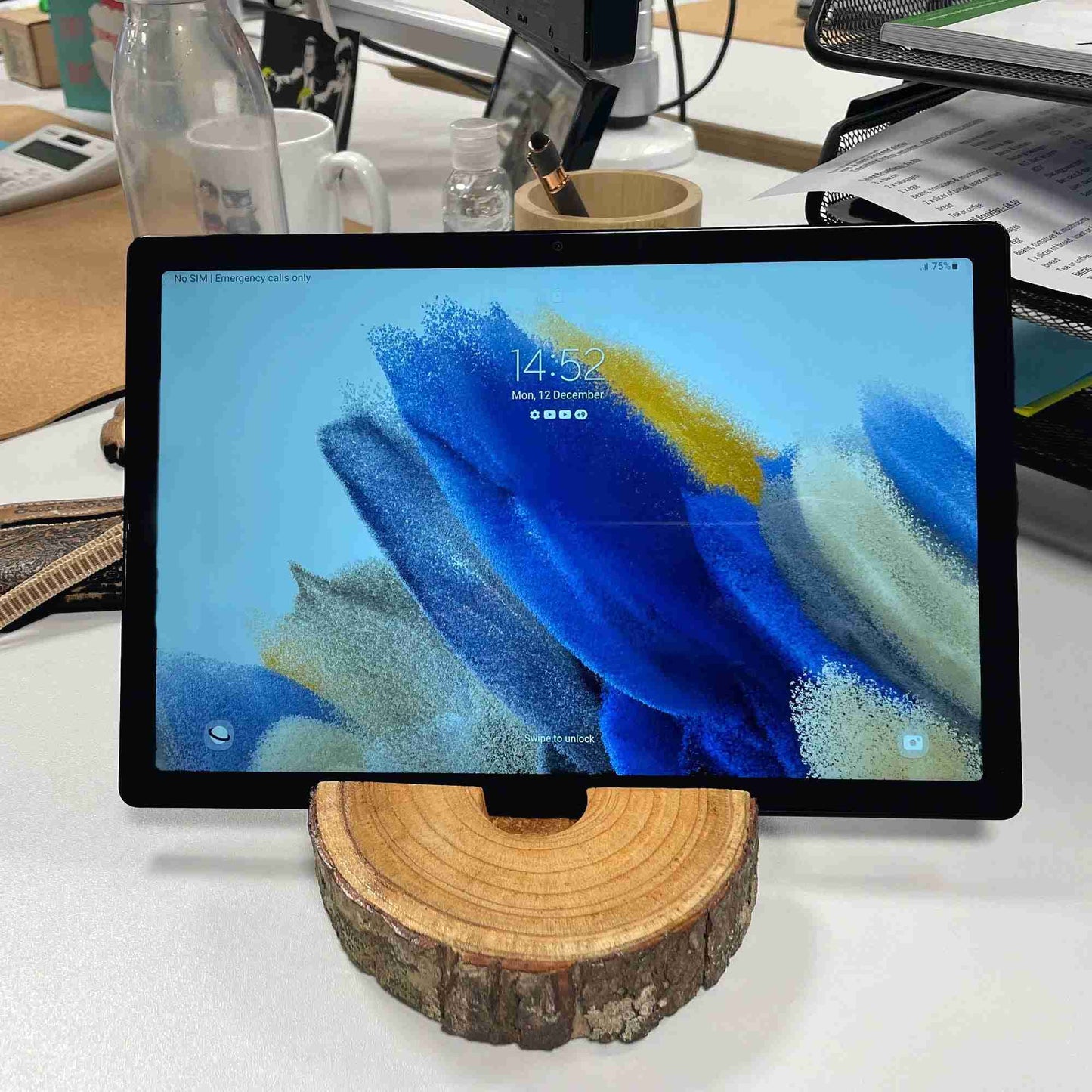 Tablet on a wooden stand with a colorful display on a desk
