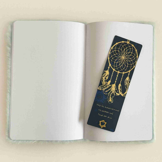 Open notebook with a dreamcatcher bookmark on a beige background