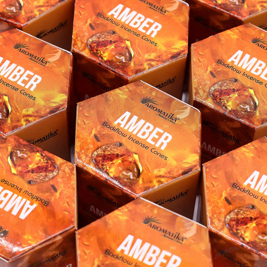 Multiple boxes of Aromatika Amber backflow incense cones arranged in a pattern.