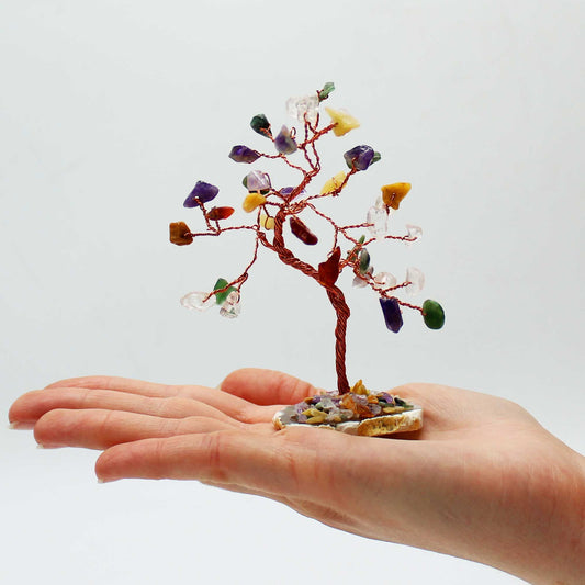 Small crystal tree on a hand against a white background