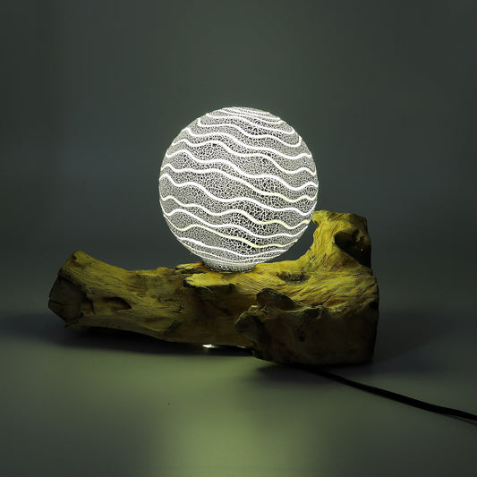 Decorative lamp with wavy pattern on a wooden base against a dark background