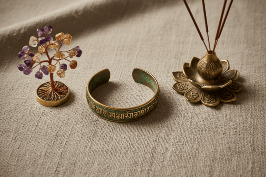 Handmade artisan gifts including Tibetan brass mantra bracelet, gemstone crystal tree, and antique incense holder on natural linen background