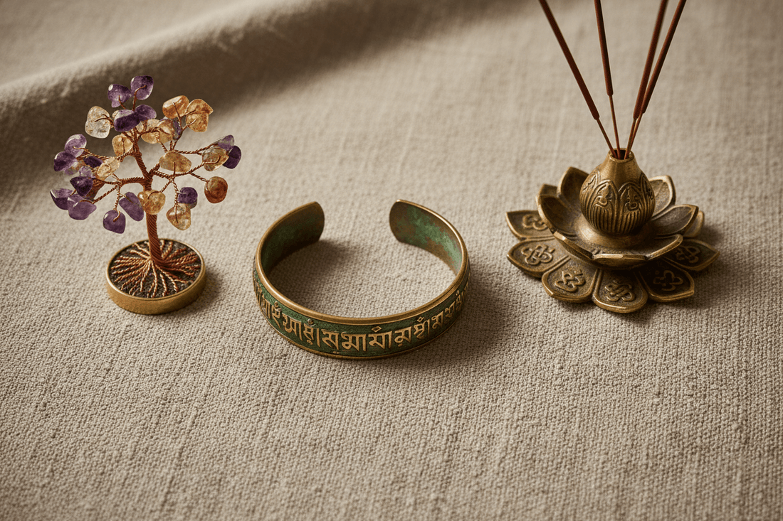 Handmade artisan gifts including Tibetan brass mantra bracelet, gemstone crystal tree, and antique incense holder on natural linen background