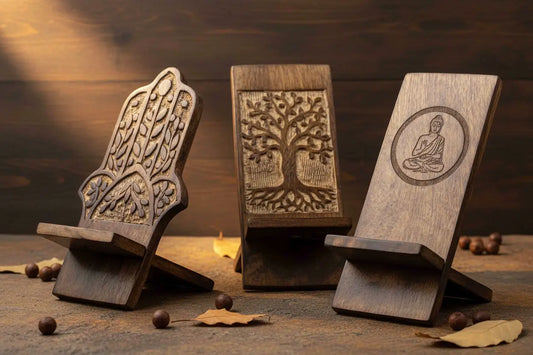 Three handcrafted wooden phone holders. Hamsa, Tree of Life, and Buddha carved designs, arranged together on a warm natural background.