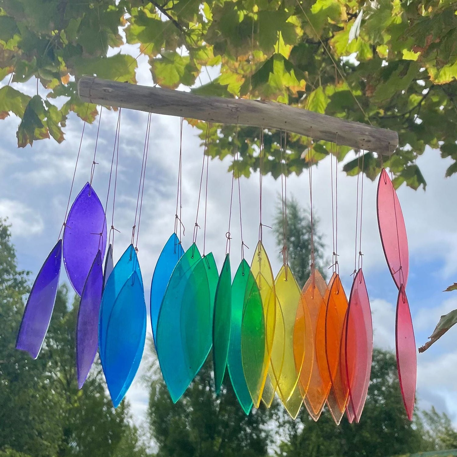 Recycled Multi Coloured Glass Wind Chimes hanging from a tree