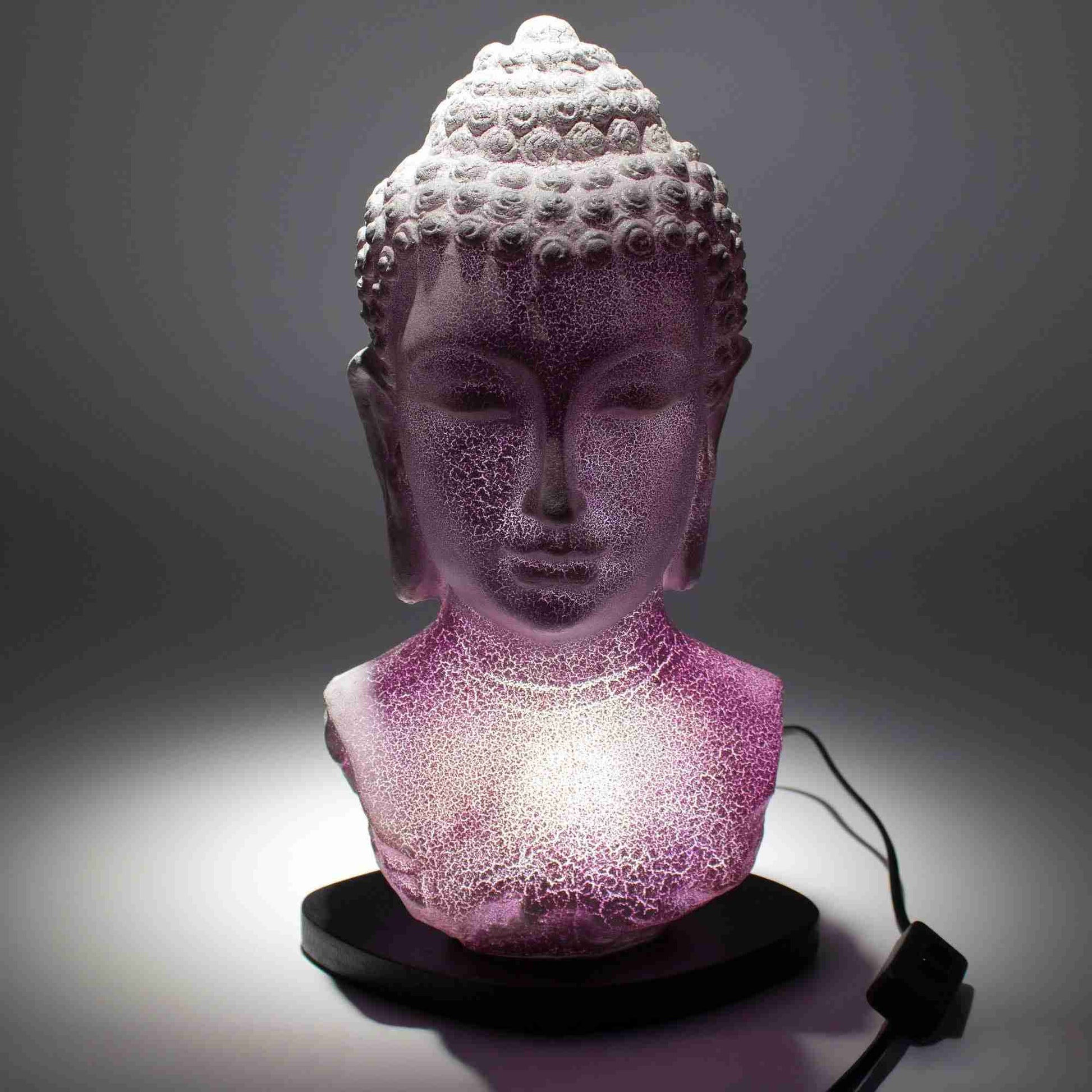 Buddha Bust Lamp Lavender Crackle with lights on a dark background.