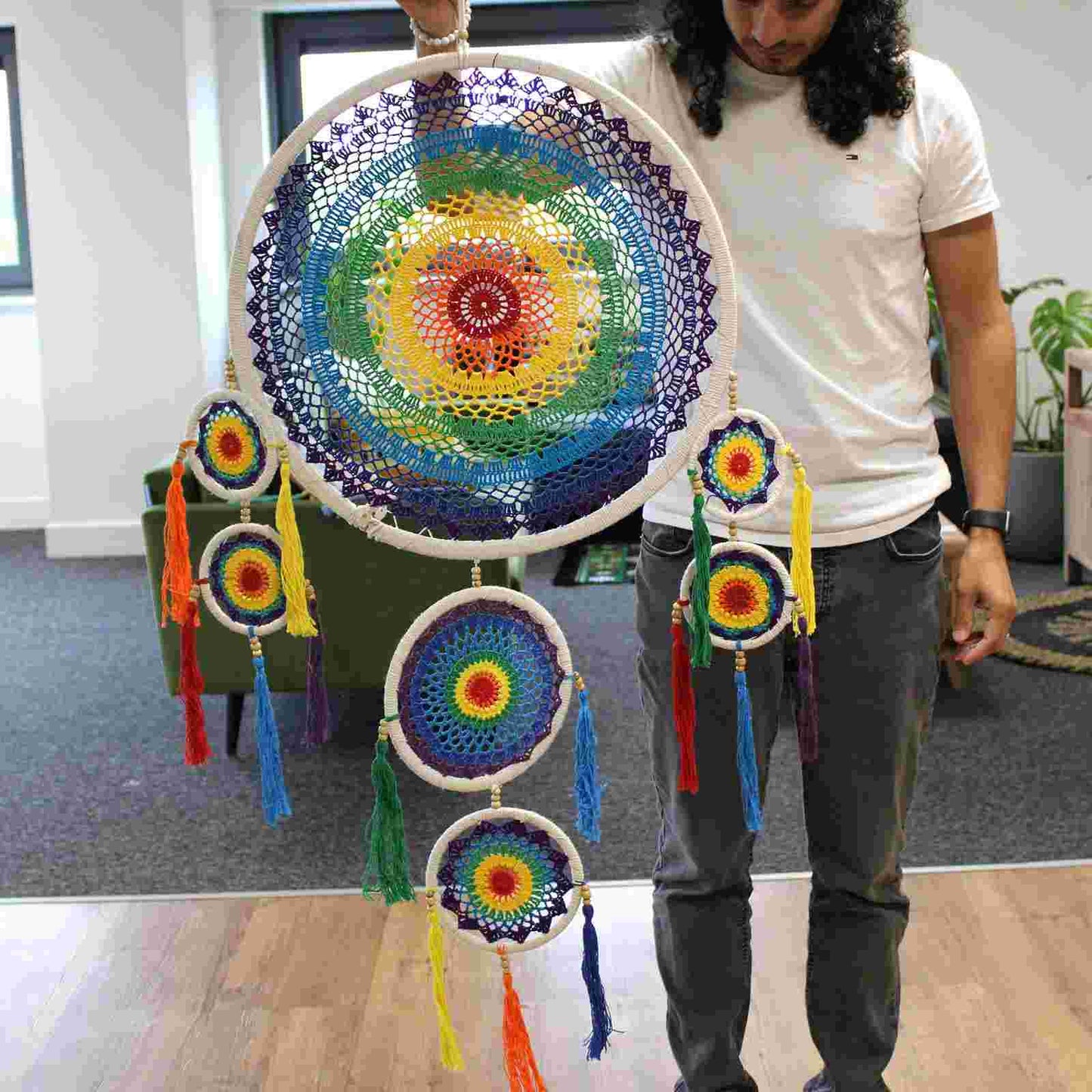 Person holding Extra Large Dreamcatcher - Vivid Rainbow in a living room setting
