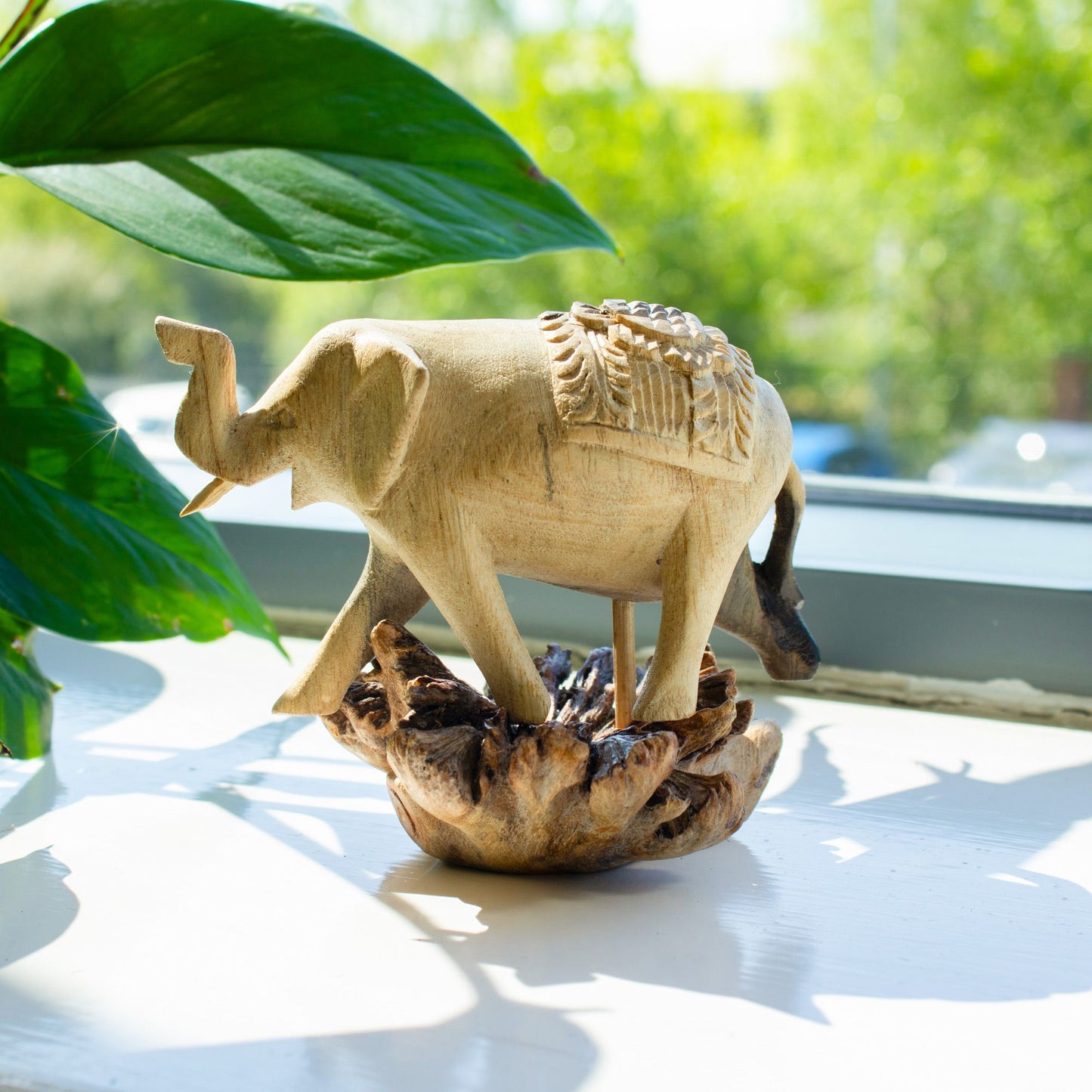 Handmade Parasite Wood Art Carving Elephant Walking with green leaves in the background