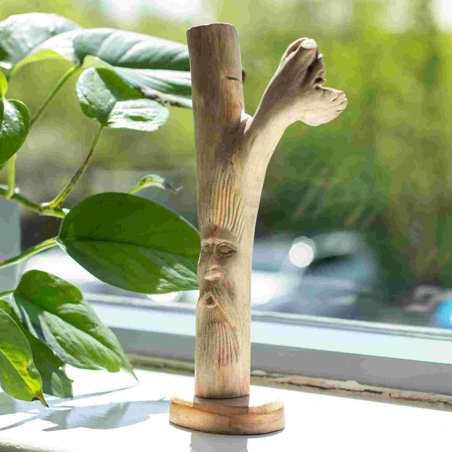 Handmade Parasite Wood Art Carving Greenman with green leaves and a window in the background
