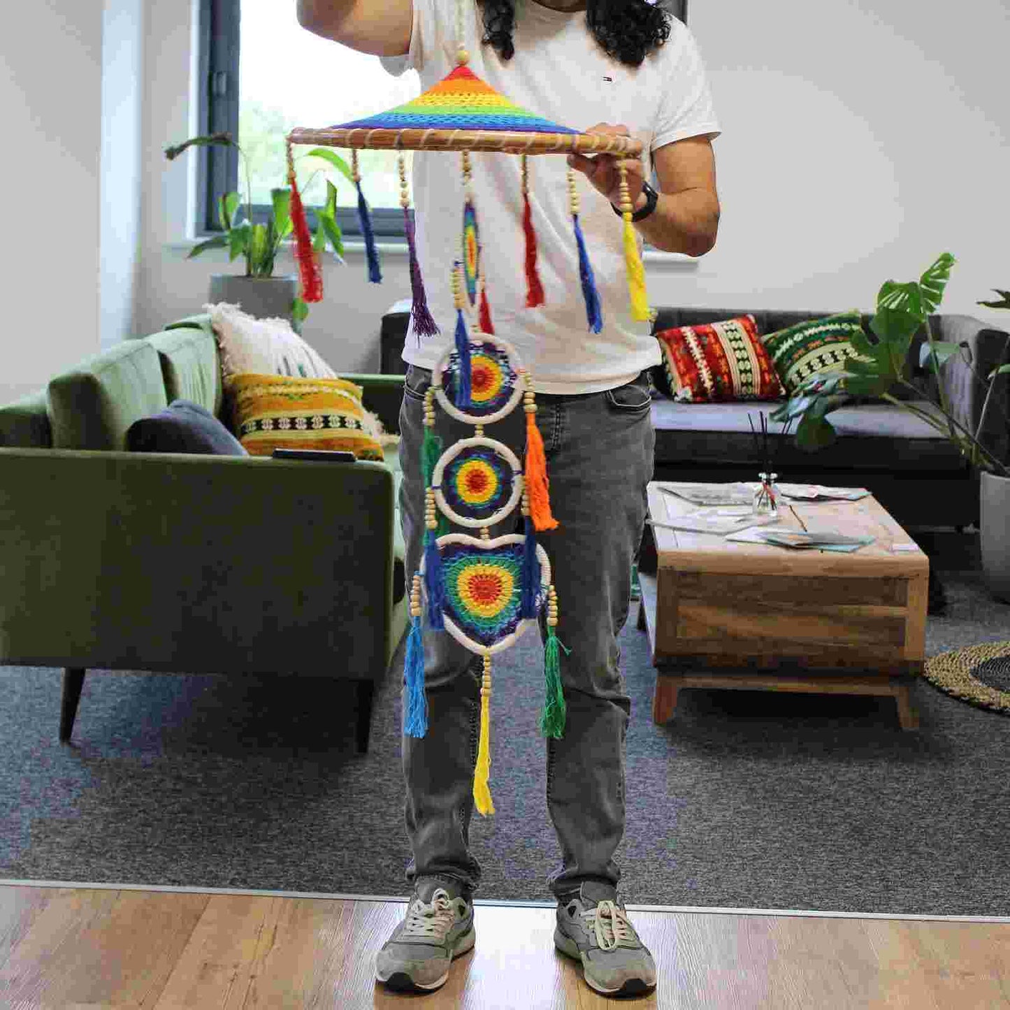 Person holding a Large Drama Dreamcatcher - Vivid Rainbow in a living room setting