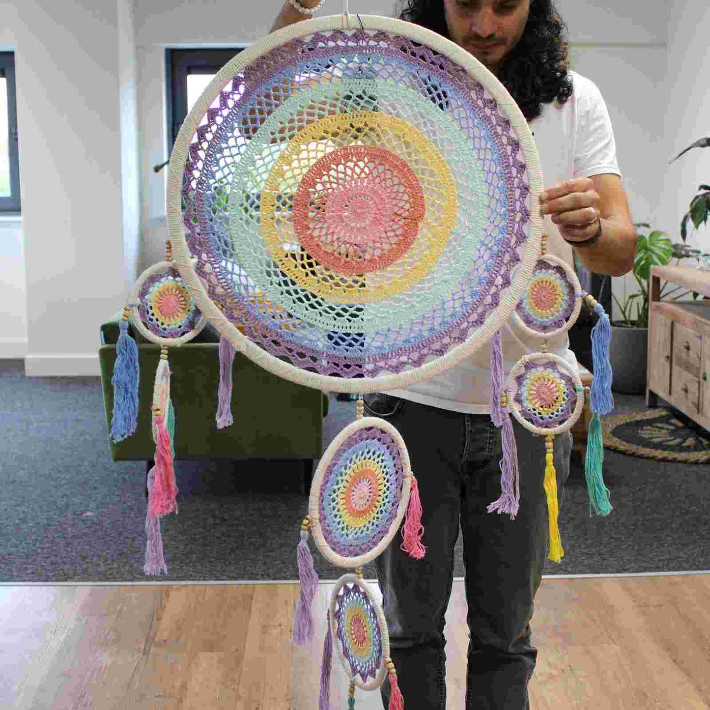 Person holding Large Dreamcatcher (55cm) - Pastel Rainbow in an indoor setting