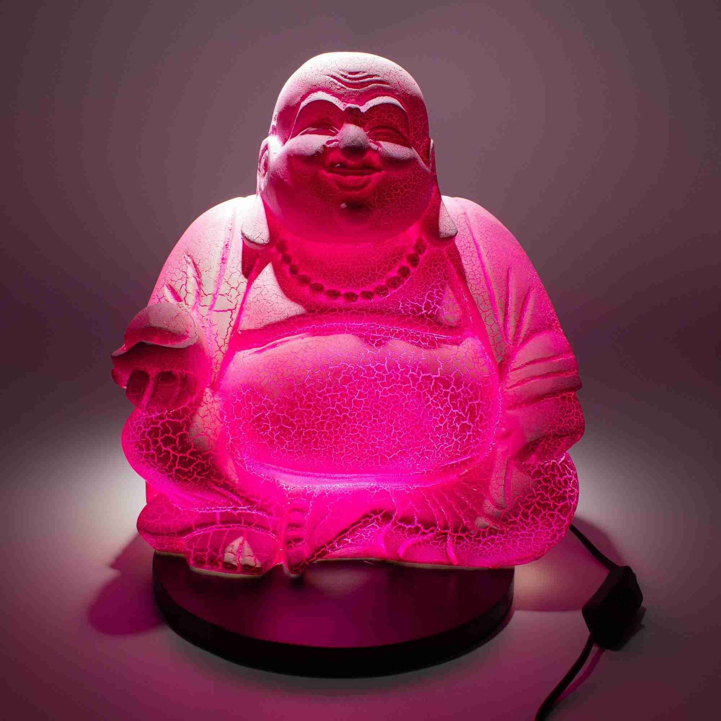Laughing Buddha Lamp Dragonfruit with light on with a dark background.
