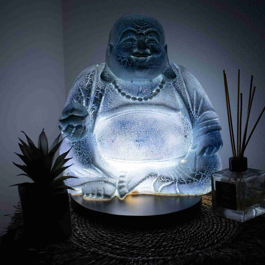 Laughing Buddha Lamp Sky Blue in a dark setting with the light on