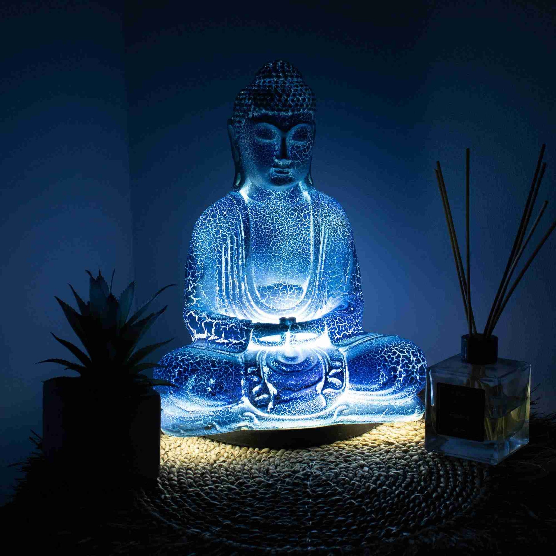 Meditation Buddha Lamp Sky Blue in a dark setting with light turned on