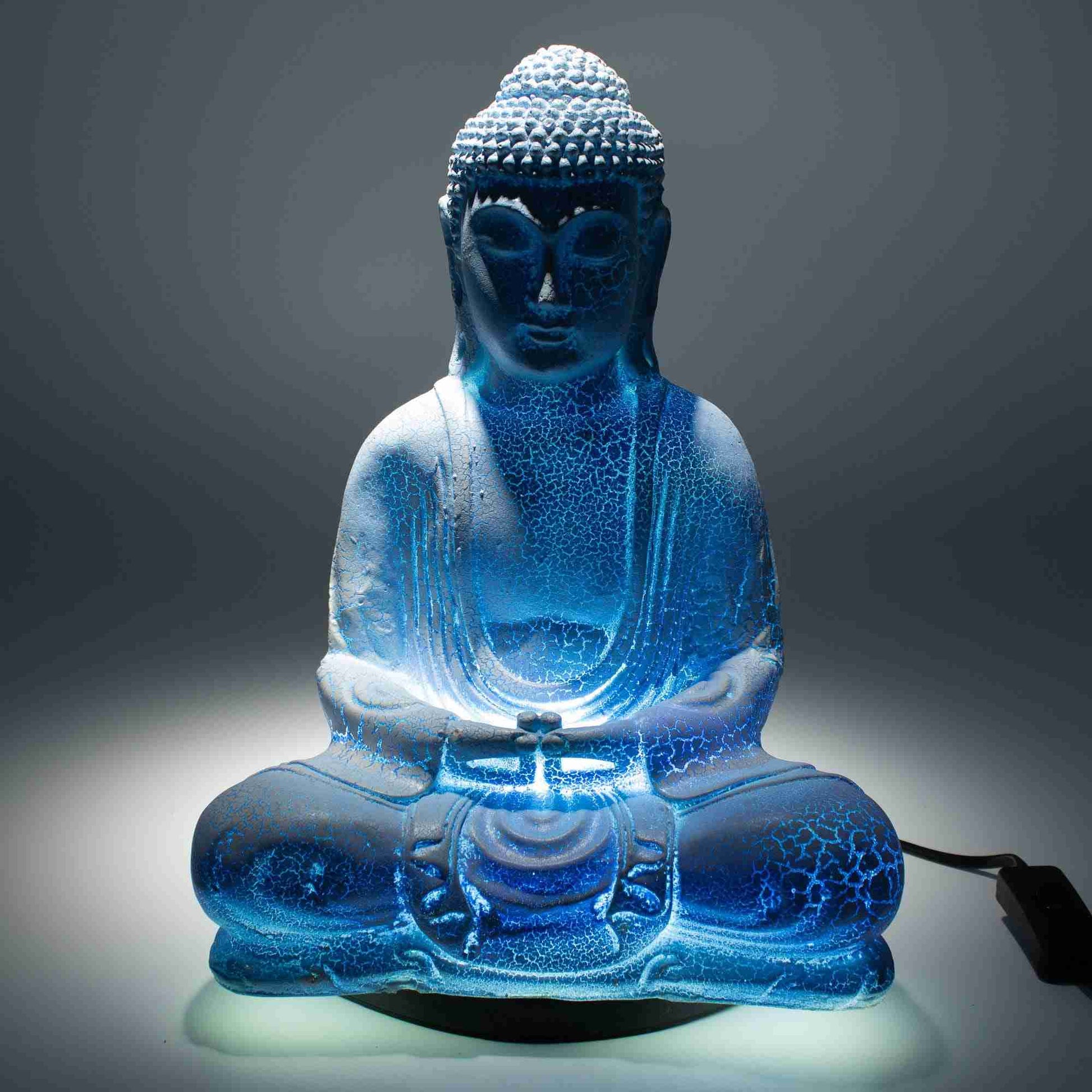 Meditation Buddha Lamp, Sky Blue with light on with a dark background.
