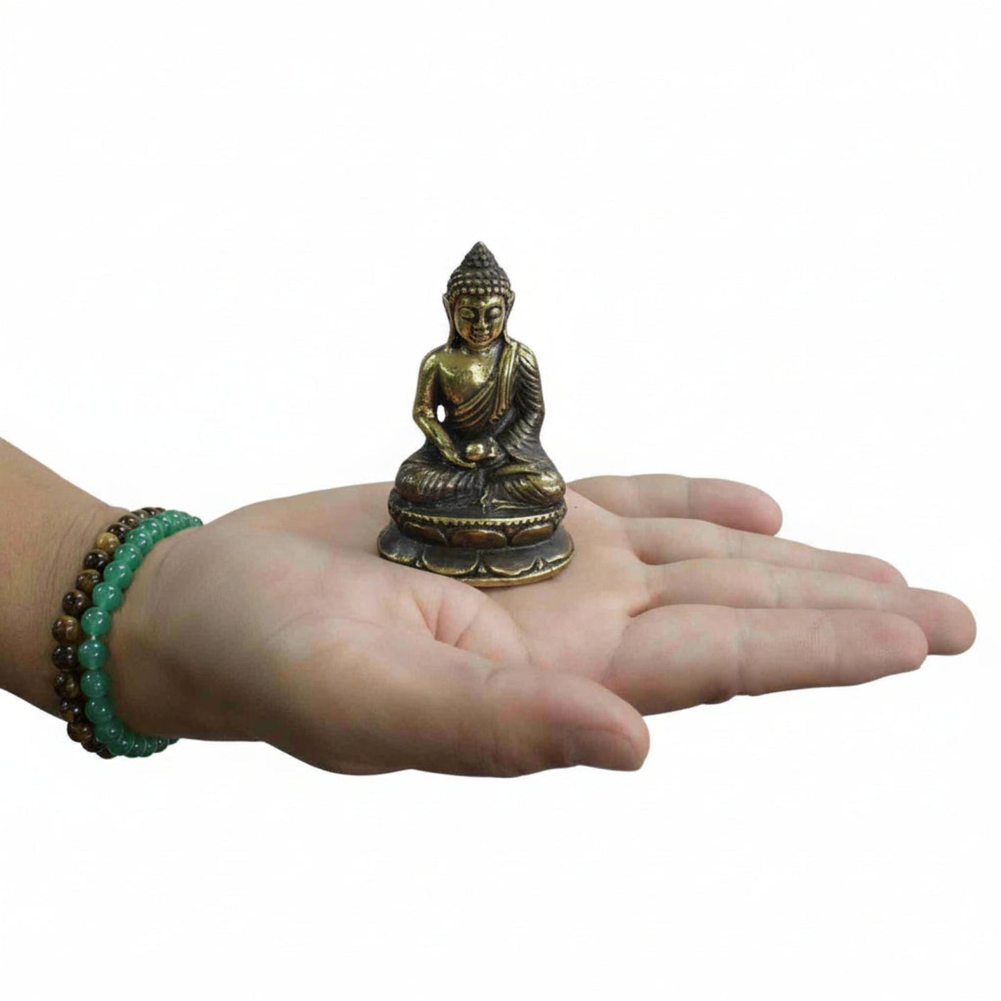 Mini Brass Buddha Figurine Sitting Meditating  held in a hand with a white background