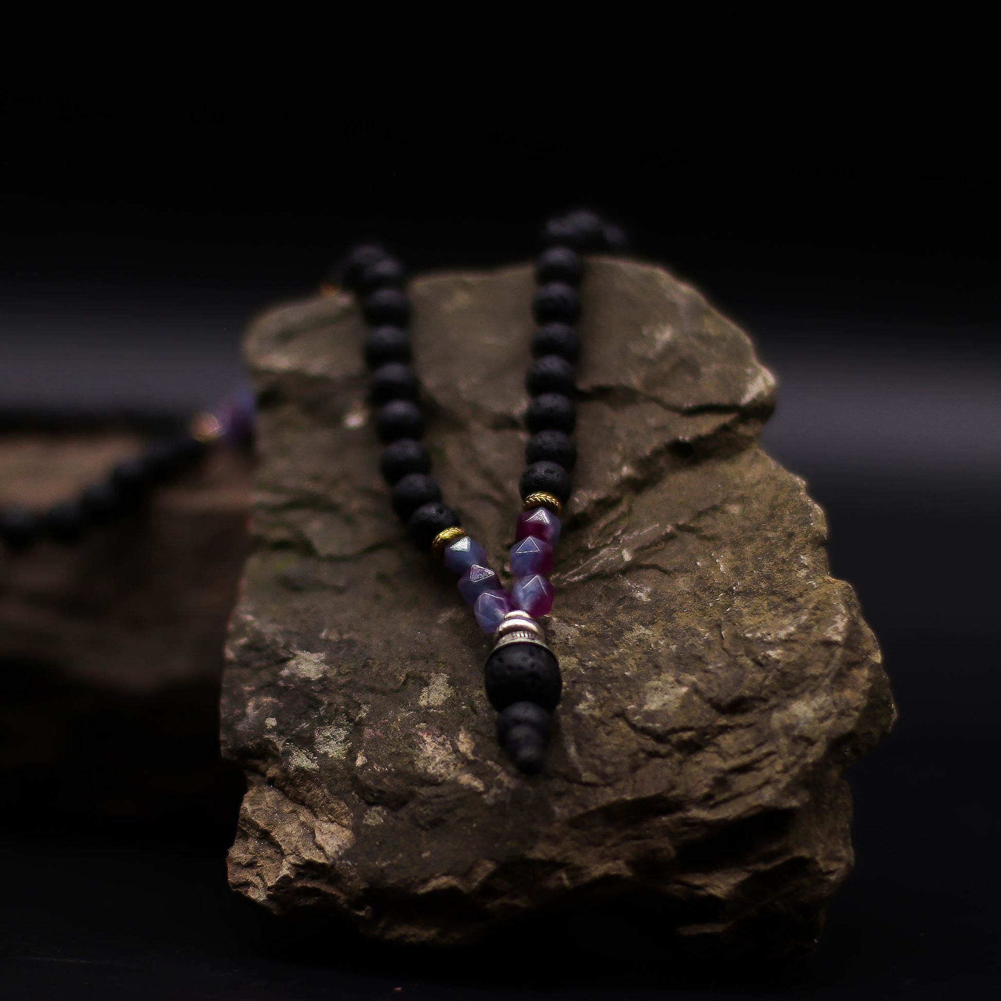 Essence of the Volcano Necklace on a dark rock background