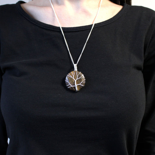 Person wearing a black shirt with Tree of Life Gemstone Necklace - Tiger Eye