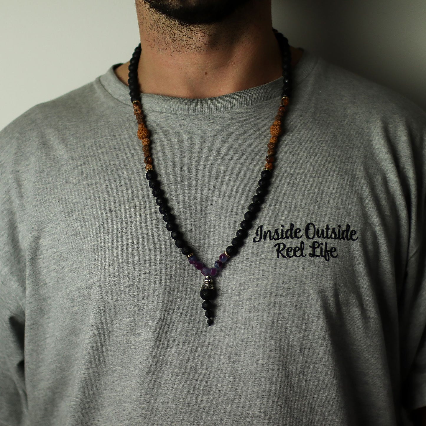 Person wearing a gray shirt with a Essence of the Volcano Necklace