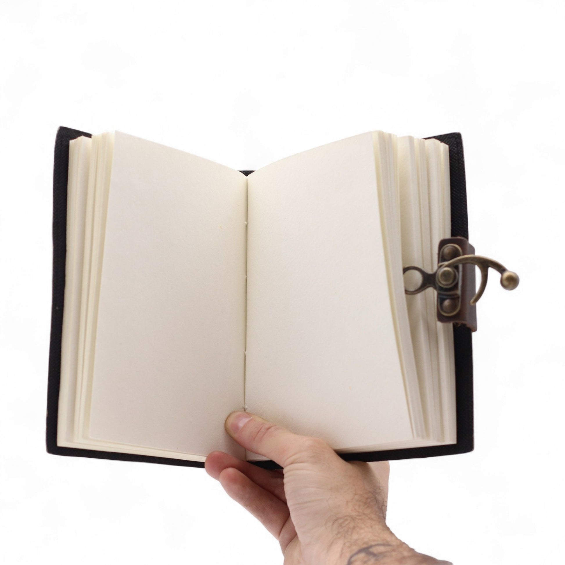 Leather Printed Notebook – Never Give Up On Your Dreams open view f pages held by a hand