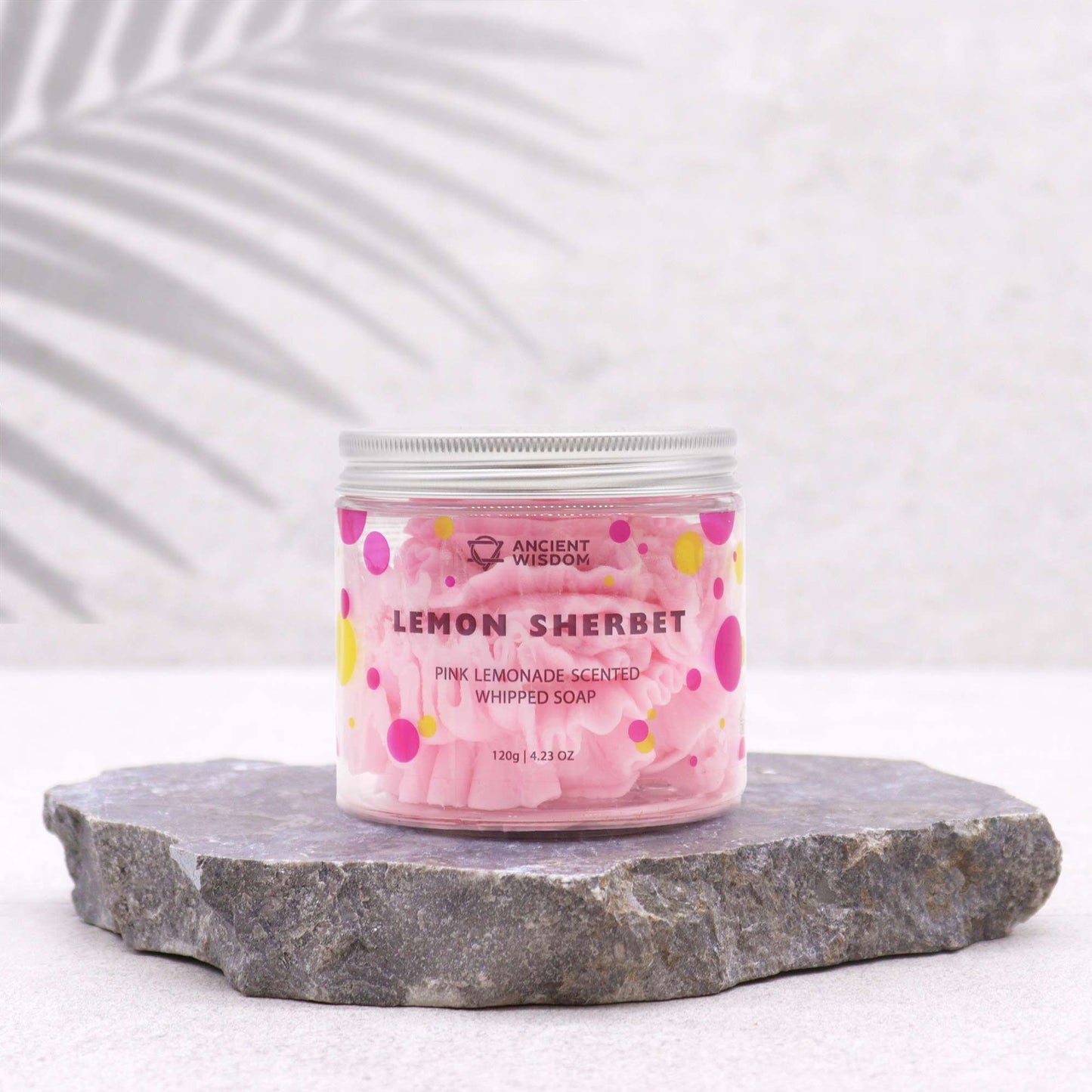 Jar of pink lemon sherbet whipped soap on a stone surface with a white background