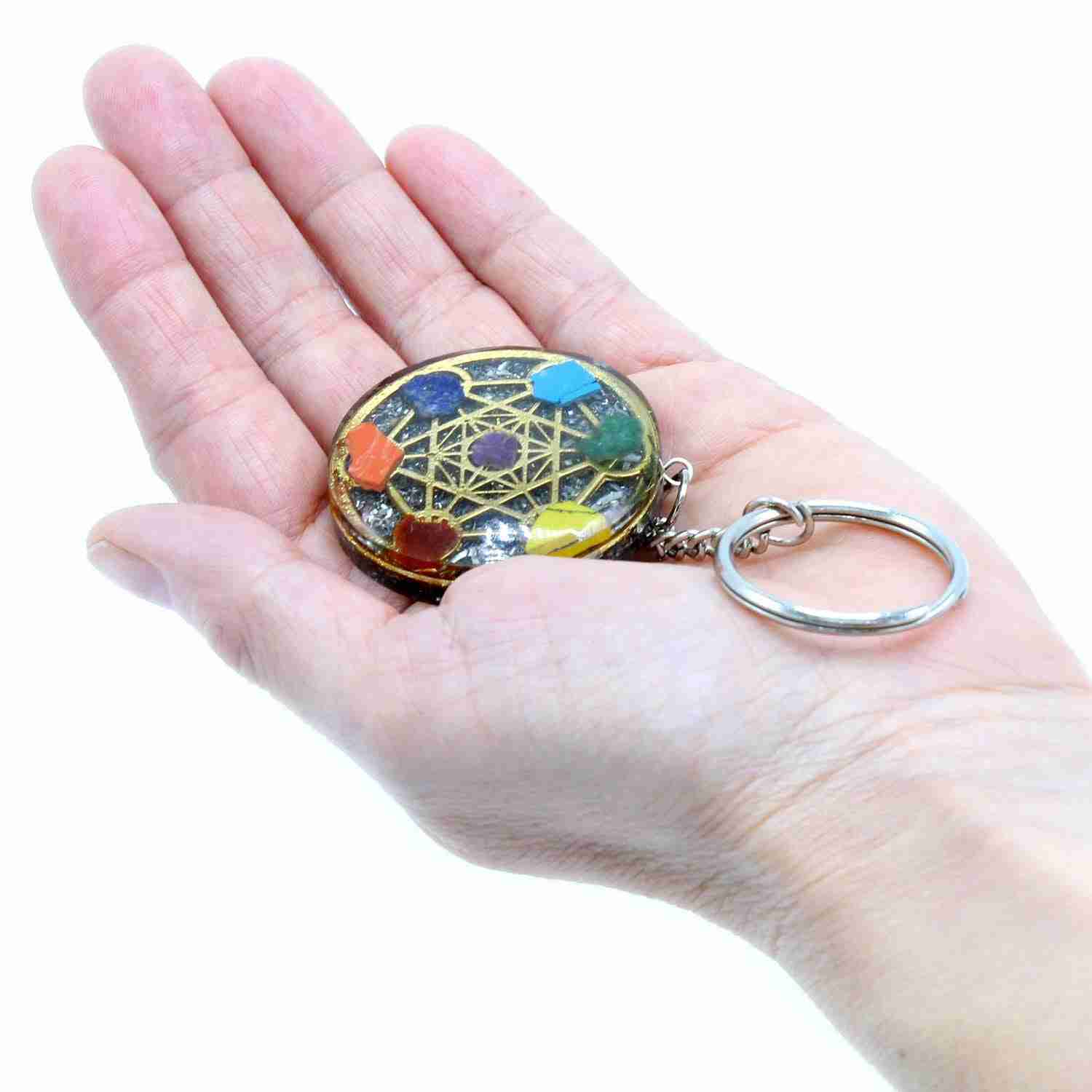 Orgonite Power Keyring - Round Seven Chakra held in a hand against a white background