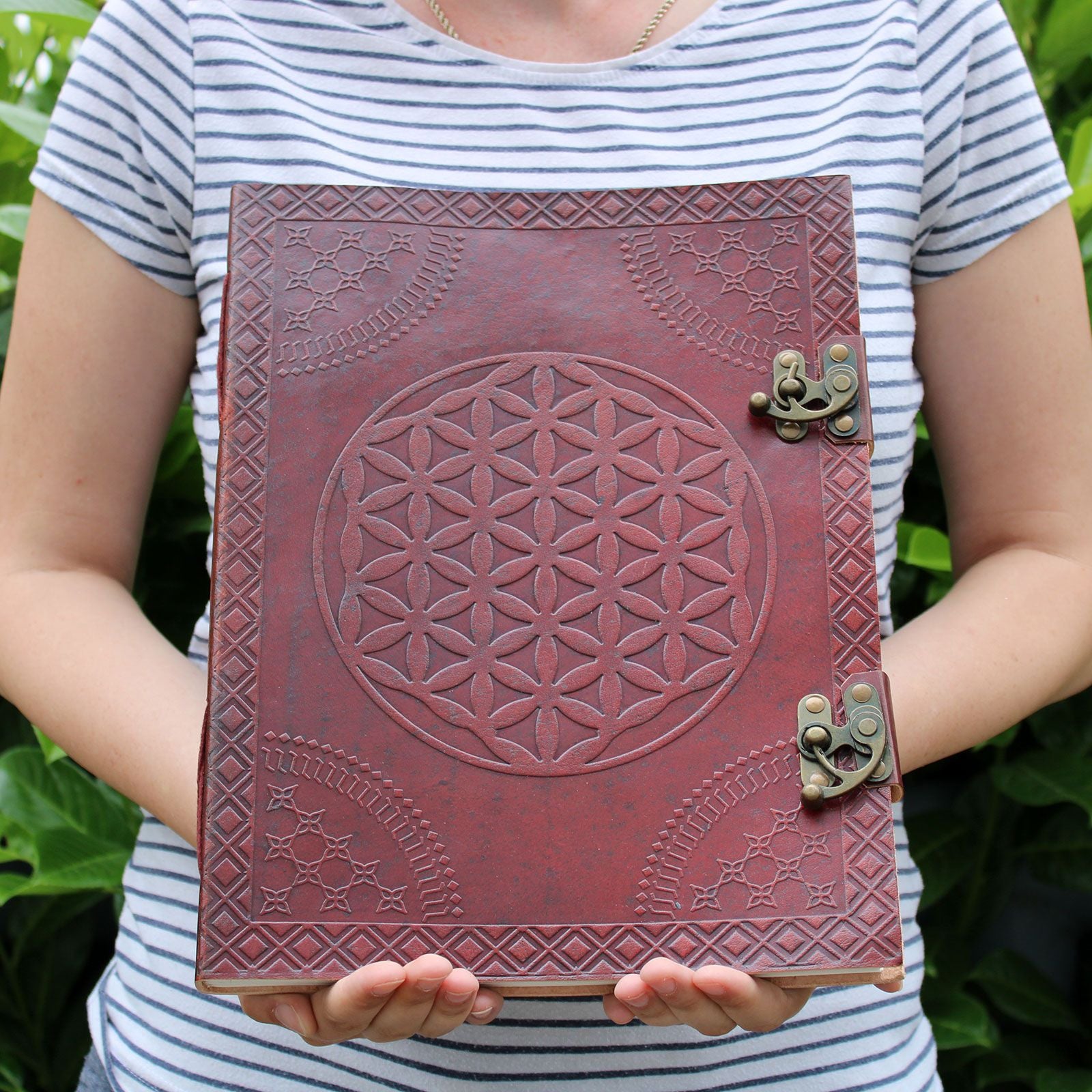 Huge Flower of Life Leather Book beig hed by a person to show size