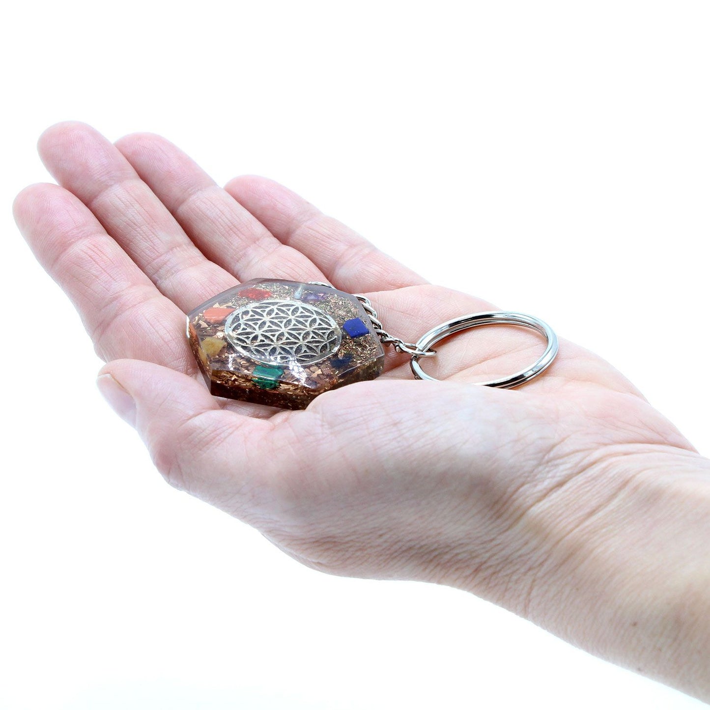 Hand holding Orgonite Power Keyring - Octagon Flower of Life on a white background