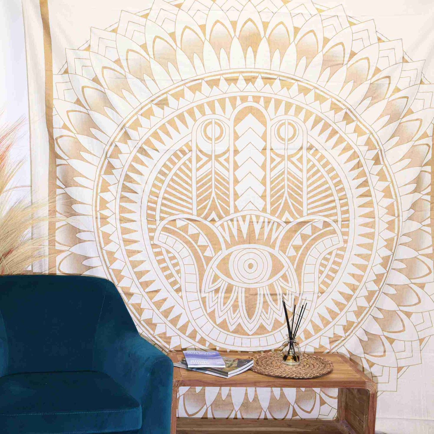 Double Cotton Bedspread + Wall Hanging - Hamsa - White Gold hanging on a wall above a blue chair.