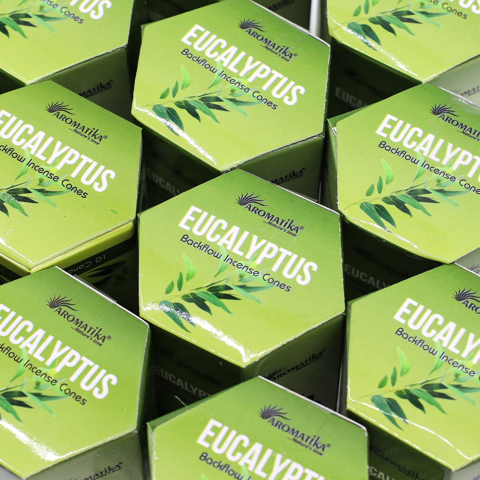 Multiple boxes of Aromatika Eucalyptus incense cones on a black background