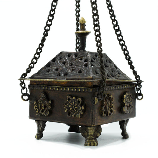 Decorative metal incense burner with intricate designs on a white background