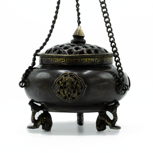 Bronze incense burner with decorative elements on a white background
