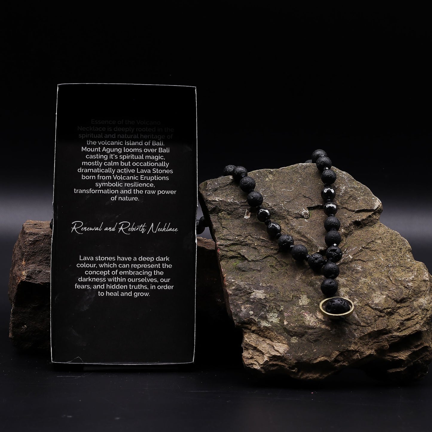 Lava stone necklace on a rock with descriptive card in front