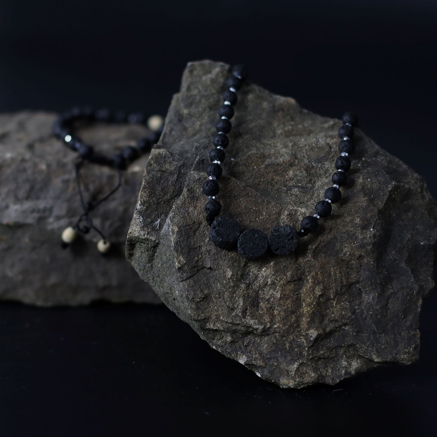 Essence of the Volcano Necklace on a dark rock with a black background